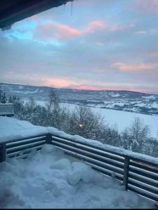 a snow covered porch with a view of a lake at All inclusive villa in Lillehammer