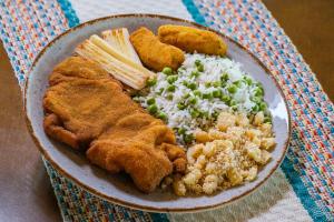 a plate of food with rice and other foods at Pousada Recanto do Amanhecer in Socorro