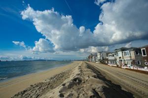 een zandstrand met huizen en de oceaan bij Peninsula Hideaway Apartment • Alamitos Bay in Long Beach