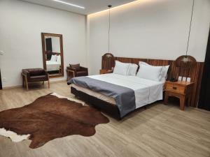 a bedroom with a large bed and a mirror at Serrano Exclusive in Tiradentes