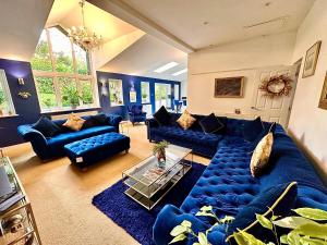 a large living room with blue couches and a table at PENDERI HOUSE USK SOUTH WALES in Usk