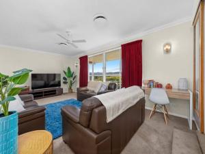 a living room with a couch and a television at Views on Quicks Hill in Lavington