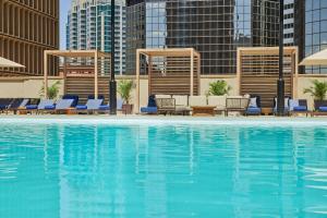 Sheraton Denver Downtown Hotel في دنفر: مسبح كبير والكراسي الزرقاء والمباني