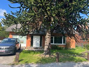 a car parked in front of a house with a tree at Les Marmottes in Éghezée