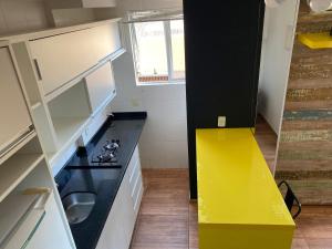 uma cozinha com uma bancada amarela e uma gaveta amarela em Studio Minimalista Região Central Residencial Padre Kolb 201C em Joinville