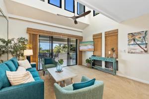 a living room with blue furniture and a fireplace at Kapalua Golf Villas 17T8 in Kahana