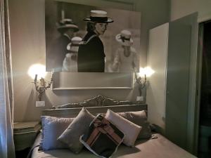 un dormitorio con una cama con una foto de un hombre con sombrero en L'Antico Lido Venice, en Lido de Venecia