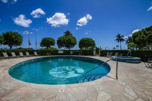 a swimming pool in a patio with chairs and trees at Home away from home 2 bdr Ocean views 1350AM in Honolulu