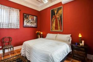 a red bedroom with a bed and a painting on the wall at Garlands Del Rio in Puerto Vallarta