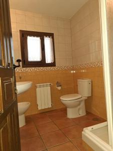 y baño con aseo y lavamanos. en Casa rural villa de lupiana, en Lupiana