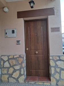 una puerta de madera en el lateral de un edificio en Casa rural villa de lupiana, en Lupiana