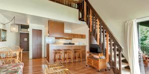 a kitchen and a living room with a staircase in a house at Molokai Shores by HI in Kaunakakai