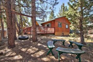 uma cabana com duas mesas de piquenique e uma casa em Los Osos w/ Privarte Spa and BBQ em Big Bear Lake