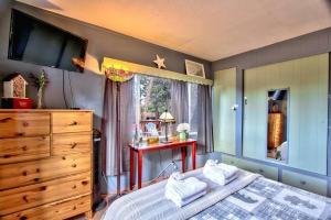 a bedroom with a bed and a dresser and a window at Los Osos w/ Privarte Spa and BBQ in Big Bear Lake