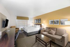 カールスバッドにあるSleep Inn & Suites Carlsbad Caverns Areaのベッドとソファ付きのホテルルーム