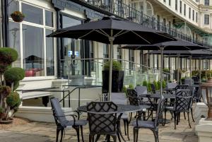 an outdoor patio with tables and chairs and umbrellas at Best Western Premier Dover Marina Hotel & Spa in Dover