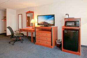 Habitación de hotel con escritorio, TV y ordenador. en Quality Inn Stadium Area, en Green Bay