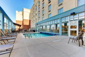 a swimming pool with chairs and a building at Drury Inn & Suites Sikeston in Sikeston