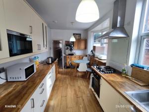 a kitchen with white cabinets and a wooden floor at St Lucia women only lodge Leicester long stays in Leicester