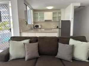 a living room with a couch and a kitchen at Meridian Tower Kirra Beach in Gold Coast