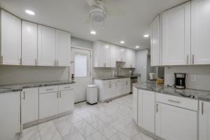 a large white kitchen with white cabinets and appliances at Fort Washington Home Close to National Harbor in Fort Washington