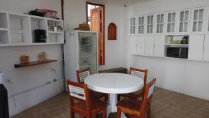 a kitchen with a white table and chairs at Hostal White House Galapagos in Puerto Ayora