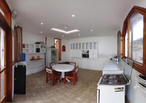 a kitchen with a table and a kitchen with a stove at Hostal White House Galapagos in Puerto Ayora