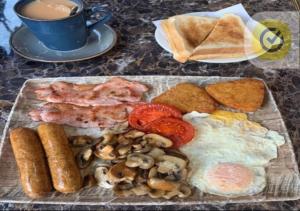 a breakfast plate with eggs mushrooms and bread and a cup of coffee at Your Riverside Home 3 with Private balcony in Woolwich