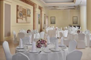 a banquet hall with white tables and chairs and flowers at InterContinental Dar Al Iman Madinah by IHG in Medina +51 photos