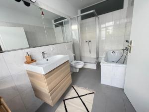 a white bathroom with a sink and a toilet at 150qm - 5 rooms - free parking - MalliBase Apartments in Hannover