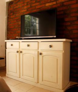 un armario blanco con TV encima en Casa El Colibrí en Capilla del Monte