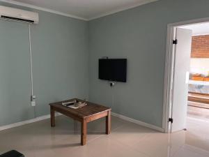 a living room with a table and a tv on a wall at Relax 6 in Paysandú