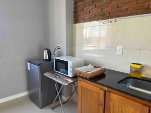 a kitchen with a counter with a microwave and a refrigerator at Relax 6 in Paysandú