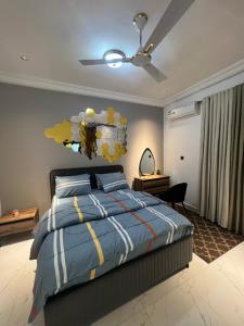 a bedroom with a bed and a ceiling fan at Akua’s Cottage in Accra