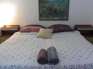 1 cama con 2 mantas y almohadas en Guest House Amfiteatar Pula, en Pula