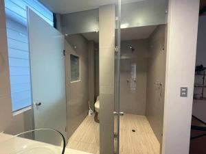 La salle de bains est pourvue d'une douche en verre et d'un lavabo. dans l'établissement Supertramp Hostel Machupicchu, à Machu Picchu