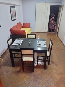 mesa de comedor negra con sillas y sofá en Bonarda II en Mendoza