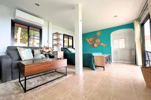 - un salon avec un canapé et une table dans l'établissement Breathtaking Sea View house from your BED - 3 min to BEACH, à Koh Samui 