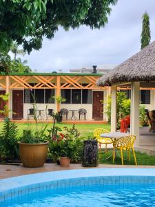 a resort with a pool and a table and chairs at Hotel Santo Vanuatu in Luganville
