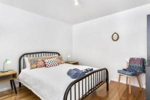 a bedroom with a bed and two chairs at Hobart studio - Yardley on Argyle in New Town