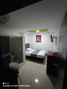 Habitación pequeña con cama y baño. en Hotel Sion Real, en Neiva