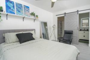 um quarto com uma cama branca e uma cadeira em Stylish 3 bedroom home near the Las Vegas Strip em Las Vegas