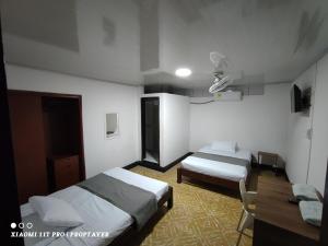 Habitación de hotel con 2 camas y escritorio en Hotel Sion Real, en Neiva