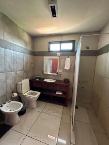 a bathroom with a toilet and a sink at Hostal del sol temporario in Rosario