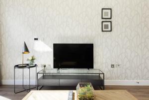 a living room with a flat screen tv on a wall at The Wentworth Apartment - Sleeps 4 in London
