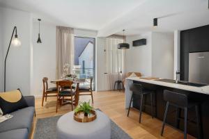 a living room with a kitchen and a living room with a table at The Retreat at Saddlers House with Private Balcony in Hobart