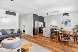 ein Wohnzimmer mit einem Sofa und einem Tisch in der Unterkunft Saddlers House - City View - Cafe Lifestyle in Hobart