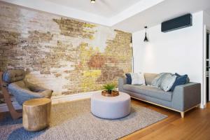 霍巴特Vintage Suite at Saddlers - Embrace a Cafe Lifestyle的客厅设有两张沙发和砖墙