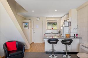 eine Küche mit einer Theke und 2 Stühlen in einem Zimmer in der Unterkunft SOHO apartment with river views stroll cafes in Hobart