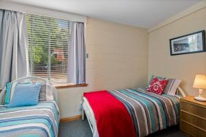 1 Schlafzimmer mit 2 Betten und einem Fenster in der Unterkunft SOHO apartment with river views stroll cafes in Hobart